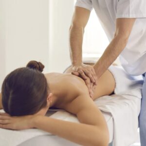 Femme recevant un massage relaxant du dos par un professionnel dans un spa.